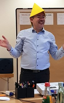 Superintendent Andreas Schwarze erl&auml;utert das Konzept mit dem gelben Hut des Optimismus, den er probehalber tr&auml;gt (Foto: R. Englert)