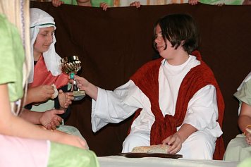 Karl Heizmann (11 Jahre) in der Rolle des Jesu reicht den Wein an seine J&uuml;nger.  (Foto: Sylvia Spehr)