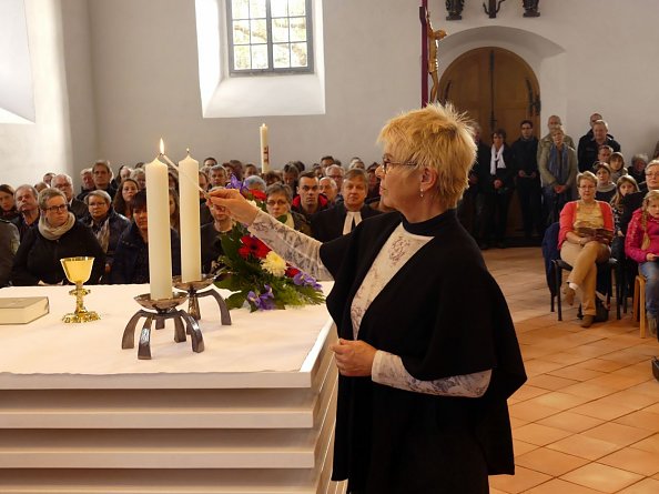 Der Altar wird geweiht - Andrea Patze entz&uuml;ndet die Altarkerzen mit dem Licht der Osterkerze (Foto: R. Englert)
